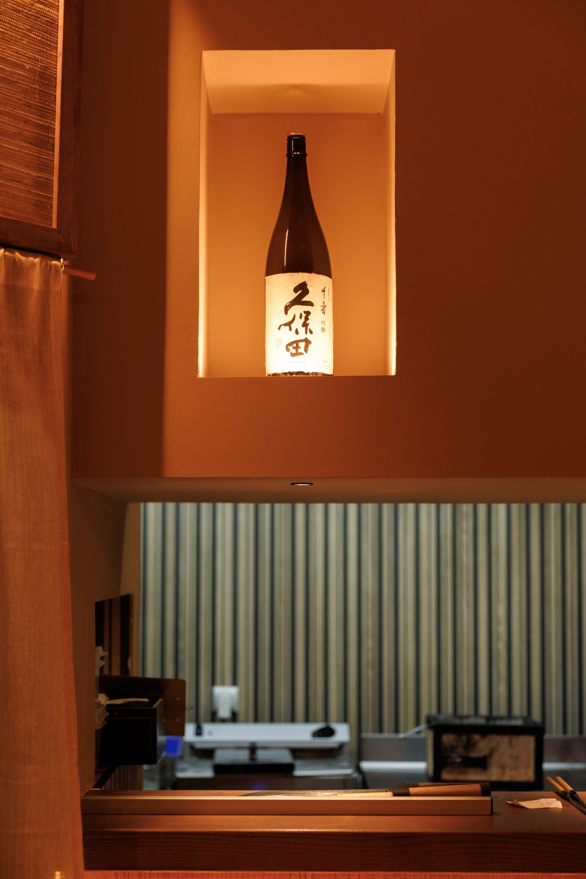 Botella de sake en la hornacina iluminada